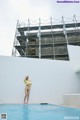 A woman standing on the edge of a swimming pool.