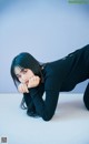 A woman laying on the ground with her hand on her chin.